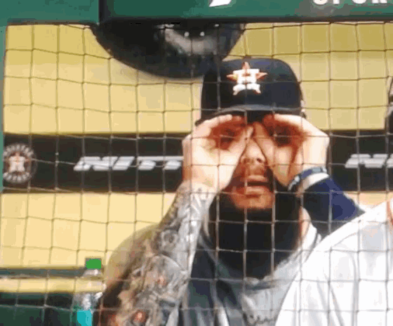 a man wearing a hat with a star on it looks through a net