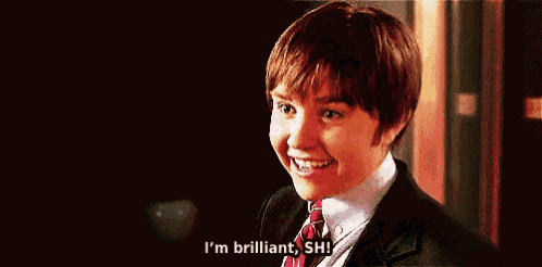 a young boy in a suit and tie is saying i 'm brilliant , shh .