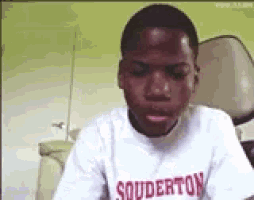 a young boy wearing a souderton t-shirt looks at the camera