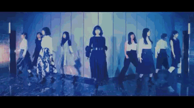 a group of women are standing next to each other in a dark room .
