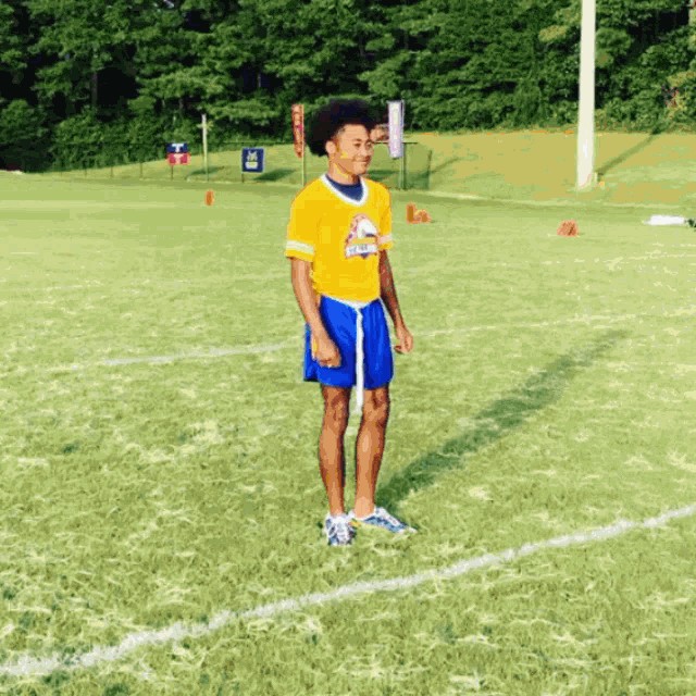 a man wearing a yellow shirt that says eagles is standing on a soccer field