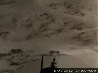 a helicopter is flying over a desert with a propeller .