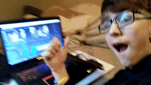 a person wearing glasses is sitting in front of a laptop computer