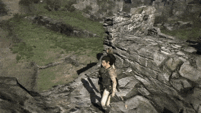 a man is standing on top of a rocky cliff holding a sword .