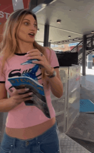 a woman in a pink shirt holds a book that says ' stef ' on it