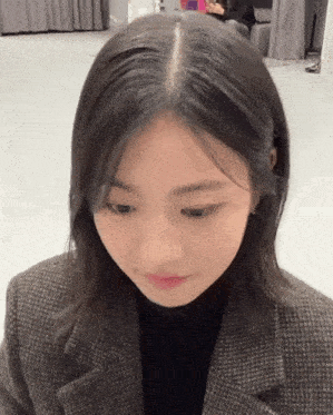 a woman with short hair is wearing a plaid jacket and a black shirt