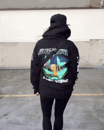 a person wearing a black hoodie that says " unleash the storm "