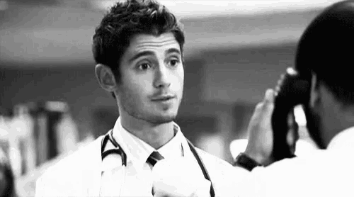 a black and white photo of a doctor talking to another doctor .