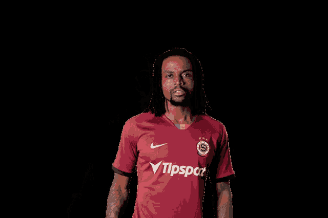 a man wearing a red shirt that says tipsport