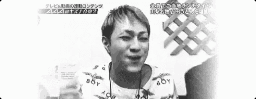 a black and white photo of a man making a funny face with his fingers .