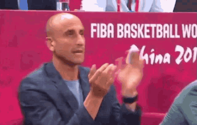 a man clapping in front of a fiba basketball world sign