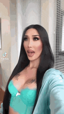 a woman with long hair is taking a selfie in a blue bra .