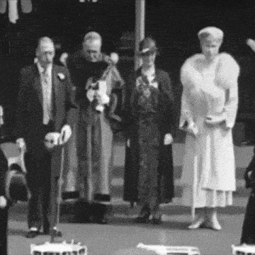 a black and white photo of a group of people standing in a line