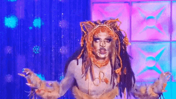 a drag queen is dressed as a lion and is dancing on a stage .