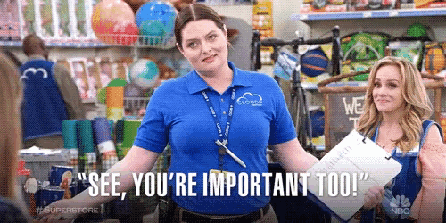a woman in a blue shirt is standing in a store and says `` see , you 're important too '' .