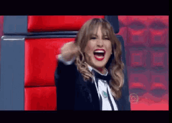 a woman in a tuxedo is sitting in a red chair