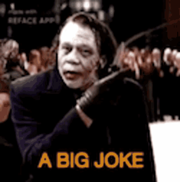 a man in a suit and gloves says a big joke in front of a crowd
