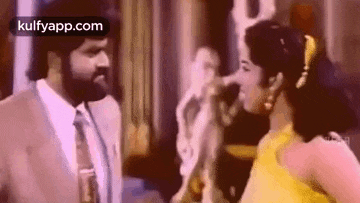 a man and a woman are standing next to each other and talking to each other .