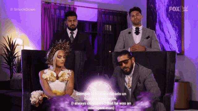 a man in a suit and tie is sitting next to a woman in a wedding dress in a living room .