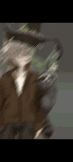 a blurry picture of a person 's face with a green leaf on it