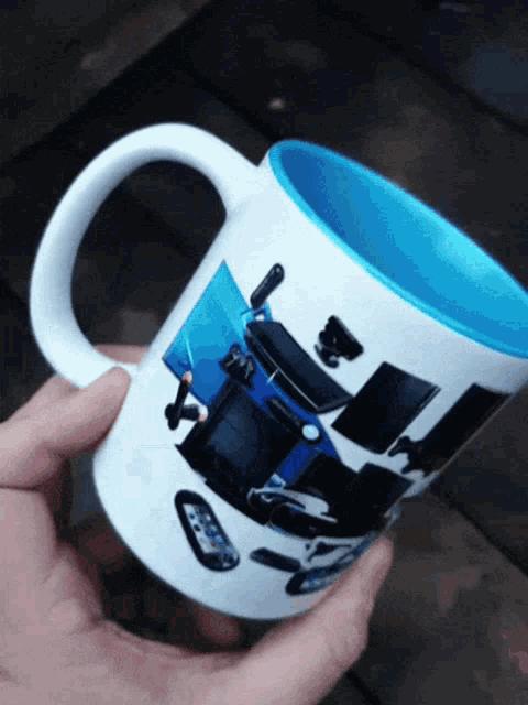 a person is holding a coffee mug with a picture of a video game controller on it