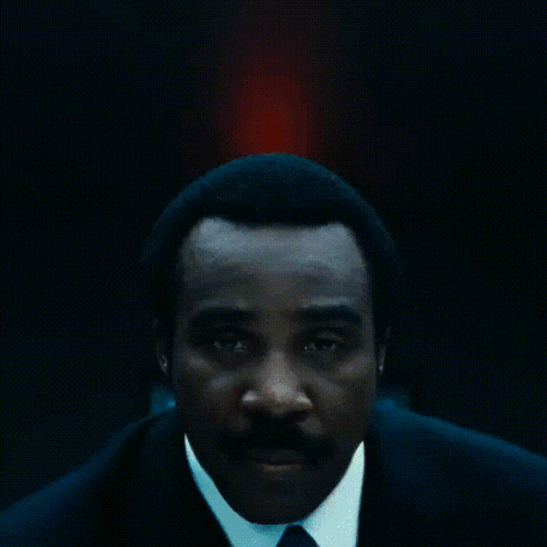 a man in a suit and tie has a blue lanyard around his neck with a key on it