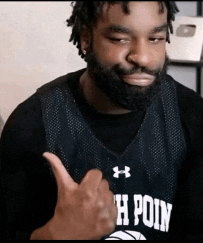 a man giving a thumbs up wearing a jersey that says point