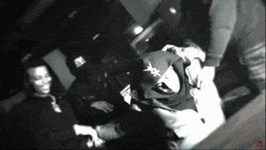 a black and white photo of a group of people with one wearing a hoodie that says x on it