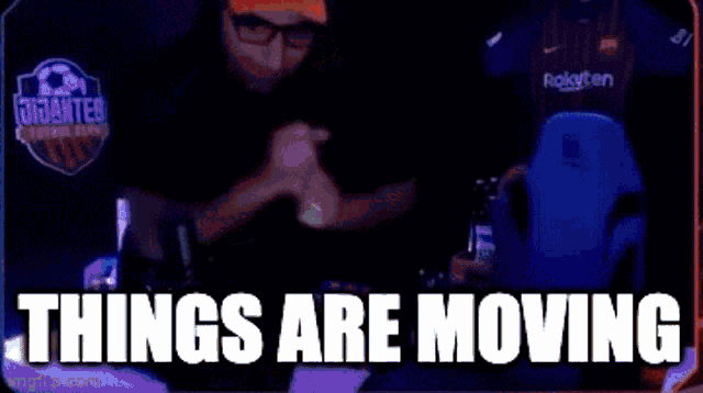 a man playing a video game with the words " things are moving " above him