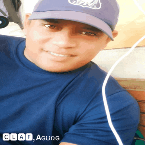 a man wearing a hat and a blue shirt with the words claf agung on the bottom right