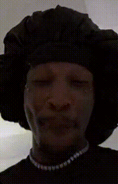 a man wearing a black hat and a pearl necklace is crying with his eyes closed