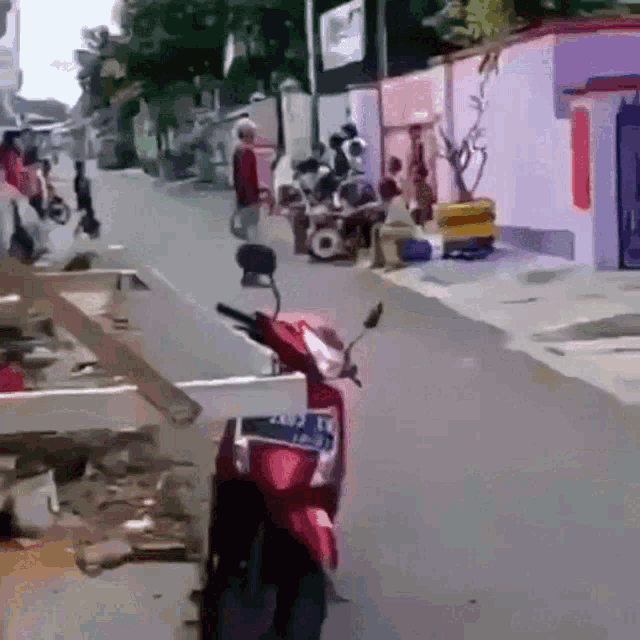 a red motorcycle is parked on the side of a street with a license plate that says jlm