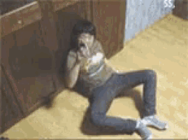 a woman is sitting on the floor with her legs crossed and talking on a cell phone .