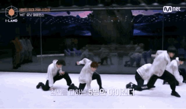 a group of young men are kneeling down in front of a mirror with the words mnet on the bottom