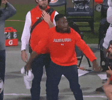 a man wearing a red auburn shirt is dancing