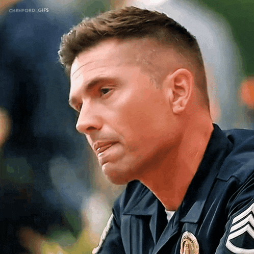 a close up of a police officer 's face with a badge on his chest
