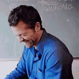 a man is laughing in front of a chalkboard that says forever is wrong