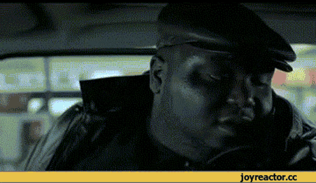 a pixelated image of a man sitting in a car with joyreactor.cc written below him