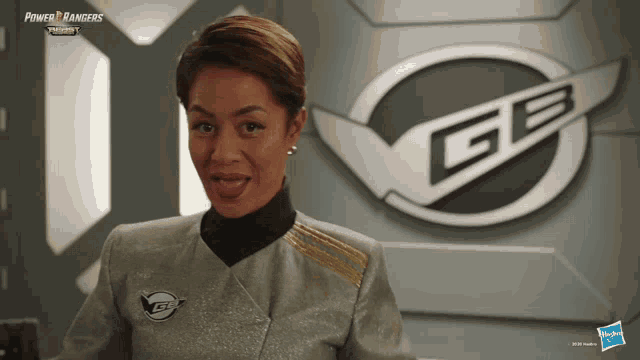 a woman in a power rangers uniform is smiling in front of a gb logo