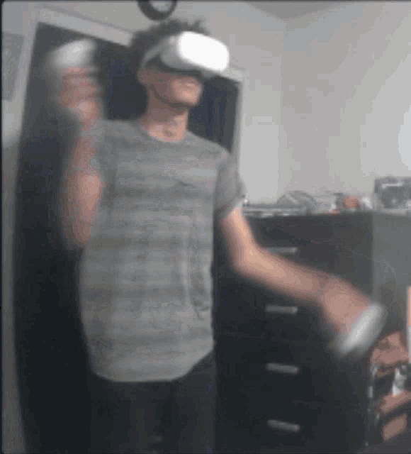 a man wearing a virtual reality headset is holding a wii controller