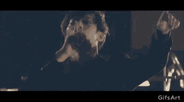 a man is playing a piano in a dark room in a video .
