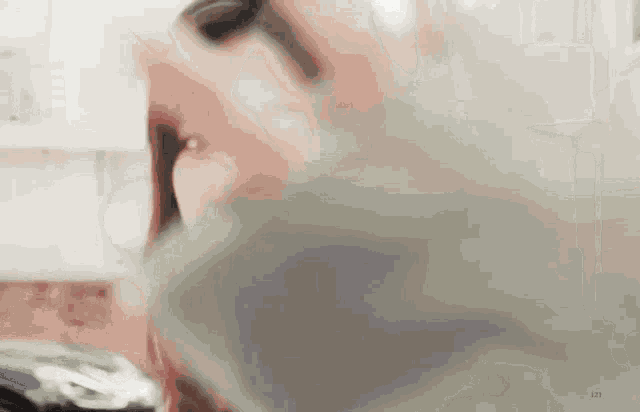 a close up of a woman 's face in a kitchen with a blurred background .