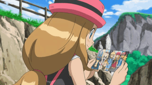a girl in a pink hat is holding a picture of a family