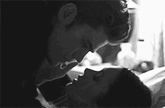 a man and a woman are kissing on a bed .