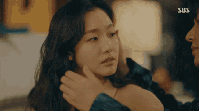 a man touching a woman 's face with sbs written on the bottom