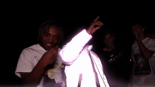 a man in a pink shirt with a smiley face on it is covering his face