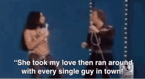 a woman singing into a microphone next to a man singing into a microphone .