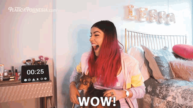 a woman with red hair is holding a dog and says wow