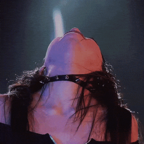 a woman with a choker around her neck looks up at something