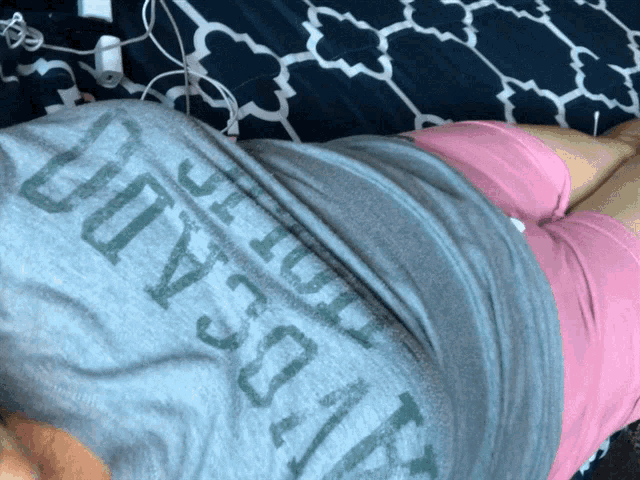 a person is laying on a bed wearing a gray shirt that says " loyalty "